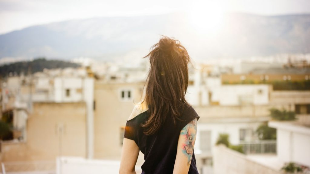 a woman with a tattoo standing on a roof